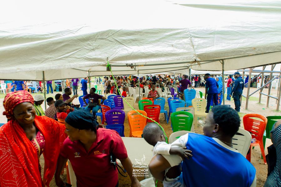 Families seated under a tent at a community outreach