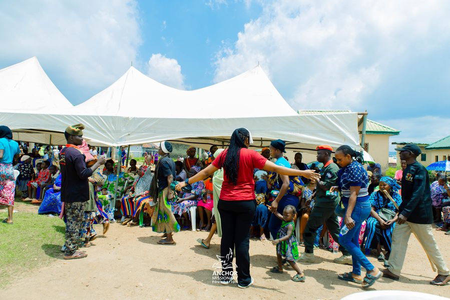A volunteer greets community members under a tent at an outreach event